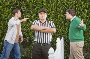 Hispanic referee between arguing neighbors